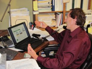 Blog author Stan Kimer on the phone presenting a power point presentation on his innovative career mapping offering over the phone to a prospective client.